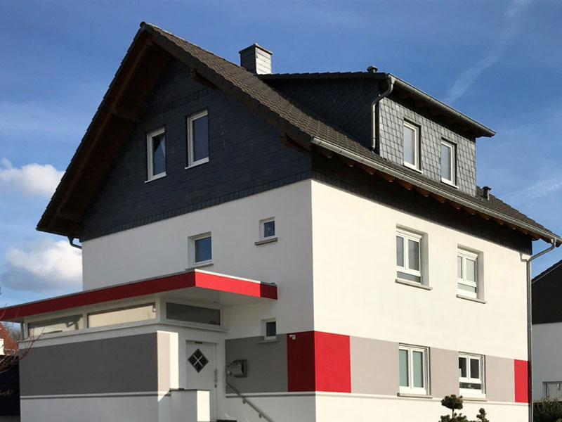 Kreativ gestaltete Fassade mit Strukturputz und Akzenten